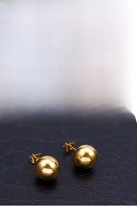 Detailed views showing 18k gold plated stainless steel ball earrings on black leather