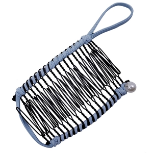 Detail of blue elastic hair clip with black metal teeth and white pearl accents