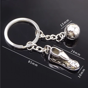 Macro detail of silver metal football and shoe keychain with dimensional measurements