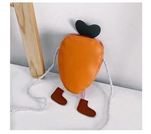 Detail view of mini carrot cross-body bag for kids with green leaves and braided strap