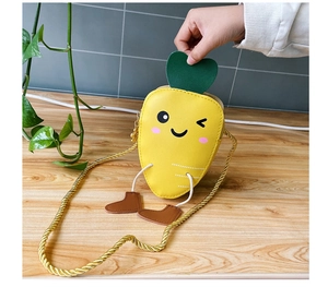 Detail of cute carrot mini crossbody bag with green leaf handle and chain strap