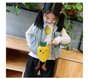 Close-up of yellow carrot-shaped kids crossbody bag with 3D leaf and leg details