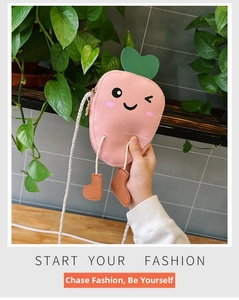 Close-up of pink carrot-shaped crossbody bag with smiling face and green heart leaf
