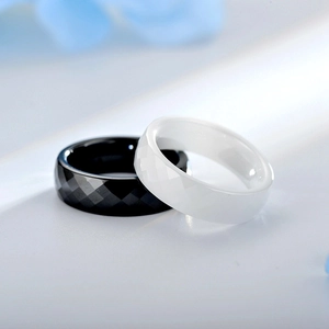 Macro shot of minimalist ceramic rings with faceted diamond-cut surface in black and white