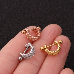 Macro detail of U-shaped zircon earrings in rose gold, silver, and gold finishes