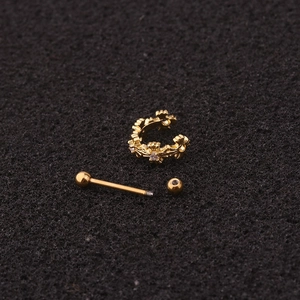Macro shot of disassembled gold flower tragus piercing with zircon and screw back ball