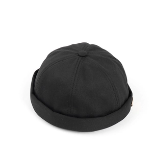 Detail of black cotton docker cap showing six-panel crown and rolled brim texture