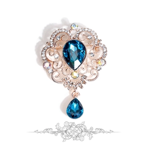 Detailed shot of baroque brooch with blue water-drop crystals and golden filigree