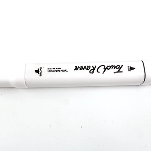 Close-up of white dual-tip marker showing Broad and Fine nibs with black branding