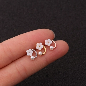 Detailed view of flower earrings with pearls in silver, gold, and rose gold finishes