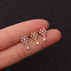 Detailed close-up of zircon snowflake cartilage studs in silver, gold, and rose gold