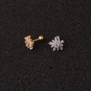 Macro shot of silver and gold crown stud earrings with clear zircon stones on foam