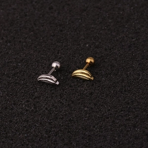 Macro view of gold and silver feather stud earrings with cubic zirconia on black foam