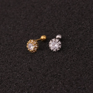 Close-up of gold and silver surgical steel ear studs with sparkling cubic zirconia stones