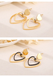 Detail view of double heart earrings in gold and black finishes on textured surface
