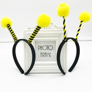 Detail of bee costume headband with yellow fluffy pom-poms and striped antennas