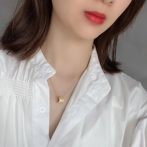 Detail of 925 silver cylinder pendant necklace with sparkling zircons on a white shirt