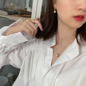 Close-up of elegant gold jewelry set with heart earrings and spinning bead necklace