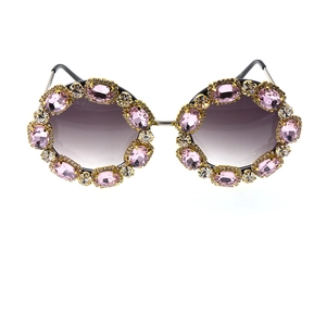 Detail of pink crystal rhinestones on oversized purple gradient sunglasses with gold frame