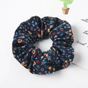 Detail of dark blue floral scrunchie with vintage blossom patterns and elastic texture