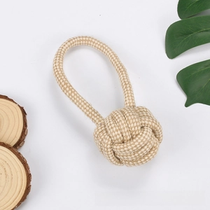 Macro detail of natural cotton rope dog chew toy featuring a durable woven ring and ball knot