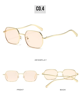 Detail view of gold polygon sunglasses with wavy temples and light orange lenses