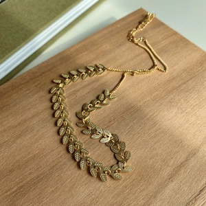 925 Sterling silver leaf chocker necklace with gold sequin finish on wood background