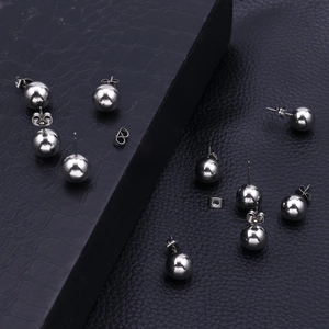 Polished silver stainless steel ball stud earrings with butterfly backs on black leather