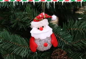 Close-up of LED Santa hanging ornament with plush details on a green Christmas tree