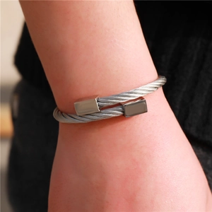 Detail van een retro roestvrijstalen kabelarmband met gepolijste vierkante uiteinden om de pols