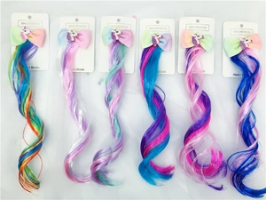 Close-up of six colorful unicorn bow hair clips with long rainbow gradient hair extensions