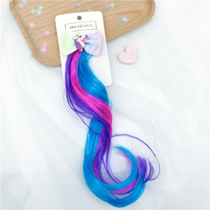 Close-up of gradient rainbow unicorn hair clip with colorful braided wig strands