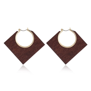 Detailed view of geometric dark wood rhombus drop earrings with golden metal loops