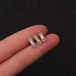 Close-up of rectangular zircon cartilage studs in gold, silver, and rose gold finishes