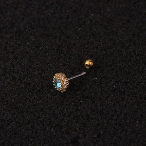 Golden cartilage piercing stud with oval blue zircon and clear stones on black background