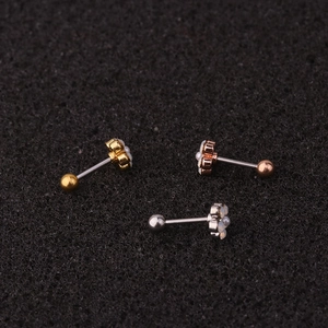 Three flower-shaped cartilage studs in gold, rose gold, and silver with opal stones