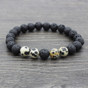 Close-up of black lava and spotted marble beads on a natural yoga stone bracelet