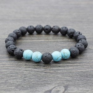 Lava rock and turquoise yoga beaded bracelet on a dark textured wood background