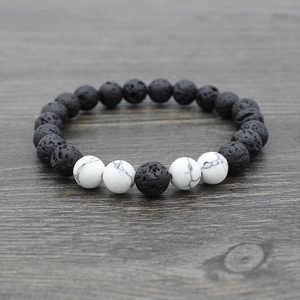 Detail of natural black lava stone and white turquoise beaded yoga bracelet texture
