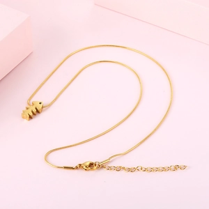 Minimalistische Gold-Fischgräten-Halskette mit Schlangenkette auf rosa Hintergrund