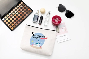 Vue à plat d'une trousse à maquillage en lin avec motif d'été et accessoires de voyage variés