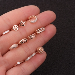 Ensemble de boucles d'oreilles et clous coeur en or rose avec zircon sur une paume