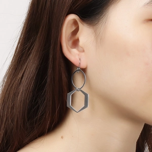 Boucles d'oreilles géométriques en acier argenté avec hexagone sur un mannequin