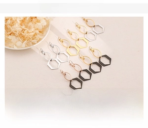 Détail de boucles d'oreilles géométriques en acier inoxydable avec pendentif hexagone