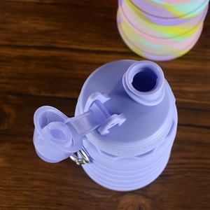 Top view of purple collapsible silicone water bottle with plastic lid and metal carabiner