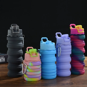 Collapsible silicone water bottles in multiple colors with carabiners on wood surface