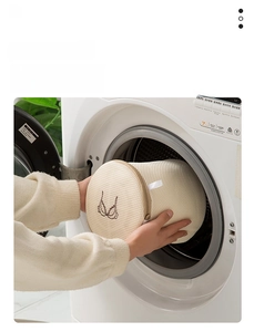 Placing a cylindrical mesh laundry bag with embroidery into a front-load washing machine