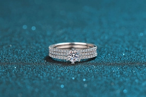 Macro shot of 925 silver moissanite ring set with round main diamond on sparkling blue background