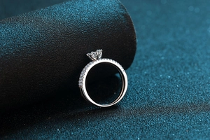 Macro shot of a 925 sterling silver six-prong moissanite ring with side stones