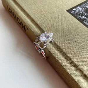 Detailed view of S925 silver crown ring with heart-shaped zircon on an olive green book